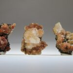 Calciet (helder met rood) kristallen op matrix